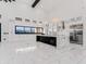 Modern kitchen features white cabinets, black island, and stainless-steel appliances at 3518 N 201St Ln, Buckeye, AZ 85396