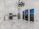 Spacious living room with kitchen features stainless steel appliances and elegant marble floors at 3518 N 201St Ln, Buckeye, AZ 85396