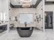 Contemporary main bathroom showcasing a freestanding tub and glass enclosed shower with tile surround at 3518 N 201St Ln, Buckeye, AZ 85396