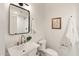Stylish bathroom with a sleek vanity, elegant mirror, white tiling and fixtures, and modern lighting at 356 W Roma Ave, Phoenix, AZ 85013
