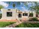 Charming home featuring stucco exterior, a red tile roof detail, black trimmed windows, and well-manicured front lawn at 356 W Roma Ave, Phoenix, AZ 85013