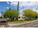 Charming home featuring stucco exterior, a red tile roof detail, black trimmed windows, and mature trees at 356 W Roma Ave, Phoenix, AZ 85013