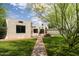 Charming home featuring stucco exterior, a red tile roof detail, black trimmed windows, and a sprawling green lawn at 356 W Roma Ave, Phoenix, AZ 85013