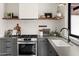 Kitchen with gray cabinets, stainless steel appliances, and open wood shelving at 356 W Roma Ave, Phoenix, AZ 85013