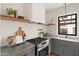 Modern kitchen with gray cabinets, stainless steel appliances, and open wood shelving at 356 W Roma Ave, Phoenix, AZ 85013