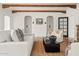 Bright living room featuring terracotta tile floors, neutral furnishings, and decorative exposed wood beam ceiling at 356 W Roma Ave, Phoenix, AZ 85013