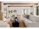Inviting living room featuring exposed beams, clay tile floors, and neutral furniture with a seamless indoor-outdoor flow at 356 W Roma Ave, Phoenix, AZ 85013