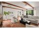 Bright living room featuring exposed wood beam ceiling, neutral furnishings, and terracotta tile floors at 356 W Roma Ave, Phoenix, AZ 85013