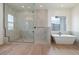 Elegant bathroom featuring a glass-enclosed shower, soaking tub, and wood-look tile flooring at 3824 W Lodge Dr, Laveen, AZ 85339