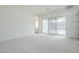 Spacious bedroom featuring neutral carpet, a sliding glass door, and access to a bathroom at 3824 W Lodge Dr, Laveen, AZ 85339
