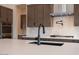 Close up on kitchen island with sink and faucet; stainless steel appliances and gas cooktop in background at 3824 W Lodge Dr, Laveen, AZ 85339