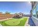 Well-maintained backyard featuring artificial grass, mini golf, brick patio, and a gazebo at 4507 S 119Th Dr, Avondale, AZ 85323