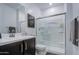 Well-lit bathroom featuring a glass-enclosed shower, dark vanity, and modern fixtures at 4507 S 119Th Dr, Avondale, AZ 85323