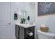 Bright bathroom with a dark vanity, toilet, mirror, and decorative wall art at 4507 S 119Th Dr, Avondale, AZ 85323