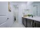 Well-lit bathroom featuring a double vanity, a large mirror, and a shower-tub combination at 4507 S 119Th Dr, Avondale, AZ 85323