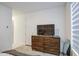 Bedroom featuring a wooden dresser with a TV, a mirror, and carpeted floors for a cozy feel at 4507 S 119Th Dr, Avondale, AZ 85323