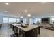 Spacious open kitchen with dark cabinetry, quartz countertops, an island, and elegant pendant lighting at 4507 S 119Th Dr, Avondale, AZ 85323