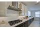 Well-equipped kitchen with stainless steel range hood, gas cooktop, and quartz countertops at 4507 S 119Th Dr, Avondale, AZ 85323