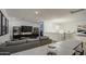 Bright and airy living room featuring a gray sofa and modern lighting fixture above the staircase at 4507 S 119Th Dr, Avondale, AZ 85323