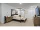 Stylized main bedroom with a four-poster bed, bench, and dresser with a wall-mounted television at 4507 S 119Th Dr, Avondale, AZ 85323