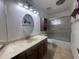 This well lit bathroom features a marble countertop, oval mirror, cabinet space, and shower and bathtub combo at 4537 E Emelita Ave, Mesa, AZ 85206