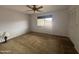 An empty bedroom with neutral walls, carpet, ceiling fan and a window that provides plenty of natural light at 4537 E Emelita Ave, Mesa, AZ 85206