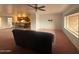 Open-concept living room with a ceiling fan and seamless flow into the kitchen area at 4537 E Emelita Ave, Mesa, AZ 85206