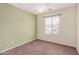 A simple bedroom with a ceiling fan and a window providing natural light at 4891 E Meadow Mist Ln, San Tan Valley, AZ 85140