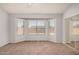 Spacious main bedroom with large windows, carpeting, and a mirrored closet at 4891 E Meadow Mist Ln, San Tan Valley, AZ 85140