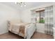 Bright bedroom featuring a decorative ceiling light, large window, and hardwood flooring at 4960 E Colonial Dr, Chandler, AZ 85249