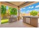 View of the outdoor kitchen with a built-in grill and bar area, perfect for entertaining guests at 4960 E Colonial Dr, Chandler, AZ 85249