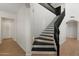 Elegant staircase with black railings and hardwood floors enhancing this inviting home entrance at 4960 E Colonial Dr, Chandler, AZ 85249