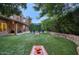 Large backyard featuring an outdoor lounge area, manicured lawn, and mature trees for privacy at 5672 E Beverly Ln, Scottsdale, AZ 85254