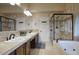 Modern bathroom featuring a double vanity, tiled shower, soaking tub, and neutral color palette at 5672 E Beverly Ln, Scottsdale, AZ 85254