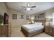 Comfortable bedroom with a ceiling fan, TV, framed artwork, and a large mirror for added brightness at 5672 E Beverly Ln, Scottsdale, AZ 85254