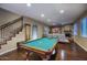 Spacious game room boasts a pool table, hardwood floors, and a cozy fireplace, perfect for entertaining at 5672 E Beverly Ln, Scottsdale, AZ 85254