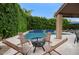 Charming patio area with modern fire pit, lounge seating, and views of the landscaped backyard at 5672 E Beverly Ln, Scottsdale, AZ 85254