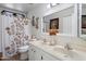 Bathroom features double sinks with framed mirror, a floral shower curtain, and decorative accents at 5808 W Acoma Dr, Glendale, AZ 85306