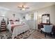 Comfortable bedroom with ceiling fan, wood-look floors, and a large window with natural light at 5808 W Acoma Dr, Glendale, AZ 85306