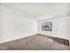 Cozy living room with neutral carpet, fresh paint, and a large window for natural light at 6313 W Carol Ave, Glendale, AZ 85302