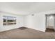 Bright living room with neutral carpet, fresh paint, and large window, offering a comfortable living space at 6313 W Carol Ave, Glendale, AZ 85302