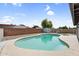 Backyard pool with updated plaster, rock surround, and partial view of patio cover at 6313 W Carol Ave, Glendale, AZ 85302