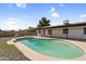 Backyard pool with updated plaster, surrounded by rocks, and a fenced-in area, adjacent to the covered patio at 6313 W Carol Ave, Glendale, AZ 85302