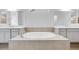 Luxurious bathroom with soaking tub situated between matching vanities and mirrors at 8426 W Solano Dr, Glendale, AZ 85305