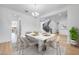 Bright dining room with a modern table set and a view of the elegant curved staircase at 8426 W Solano Dr, Glendale, AZ 85305