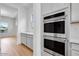 Well-equipped kitchen features stainless steel double ovens and sleek light gray cabinetry at 8426 W Solano Dr, Glendale, AZ 85305