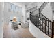 Grand curved staircase with black railing and natural light flooding the open-concept living area at 8426 W Solano Dr, Glendale, AZ 85305