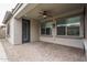 Covered back patio boasts brick pavers, a ceiling fan, and views of the beautiful outdoor space at 9041 W Redbird Rd, Peoria, AZ 85383