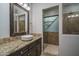 Modern bathroom with granite counters, vessel sink, dark cabinets, and glass door shower at 9041 W Redbird Rd, Peoria, AZ 85383