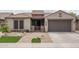 Charming home exterior featuring a well-manicured lawn, a brick walkway, and a two-car garage at 9041 W Redbird Rd, Peoria, AZ 85383